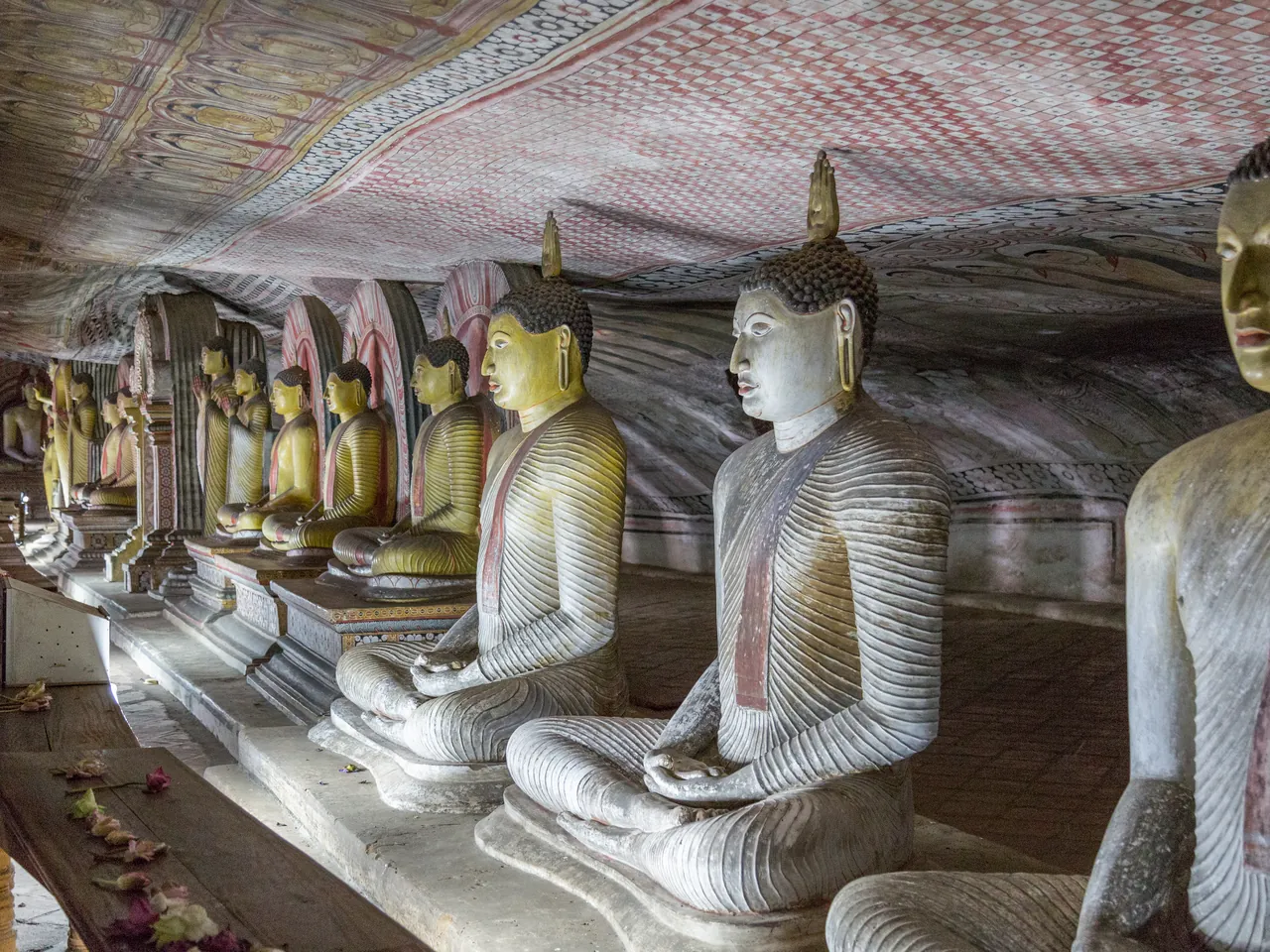 A row of seated Buddha statues inside the ancient Dambulla Cave Temple in Sri Lanka.